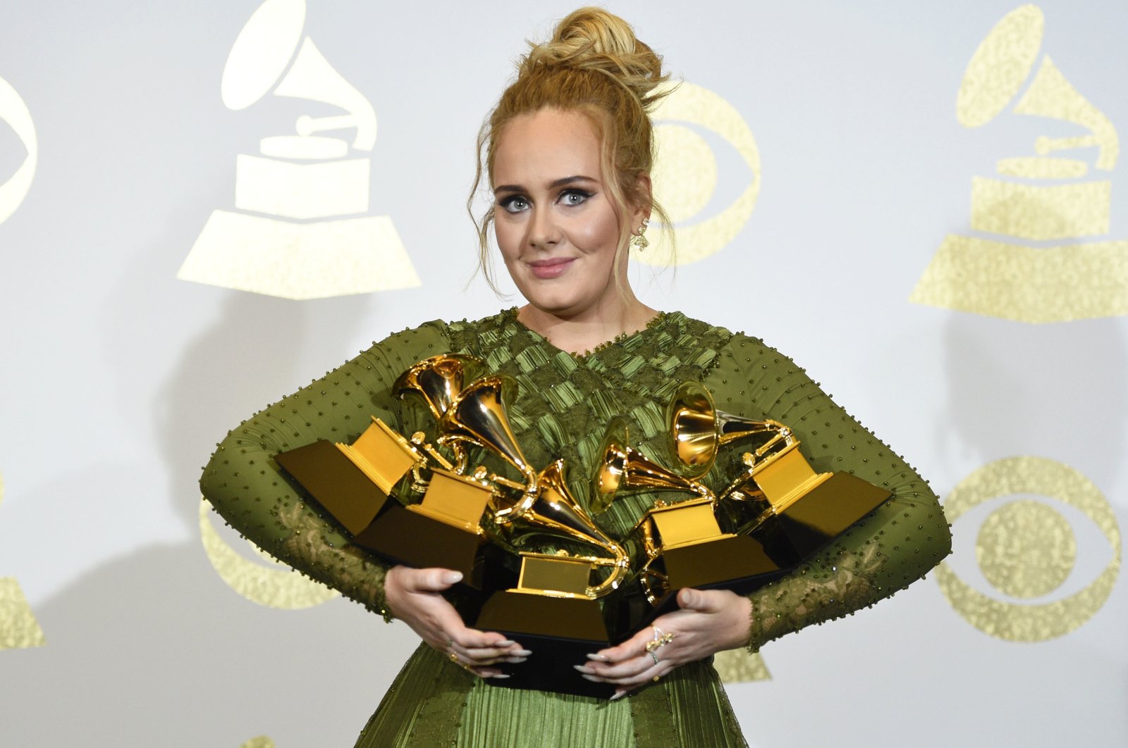 Adele poses in the press room with the awards for album of the year for "25," song of the year for "Hello," record of the year for "Hello," best pop solo performance for "Hello," and best pop vocal album for "25" at the Grammy Awards in Los Angeles, U.S., Feb. 12, 2017. (AP Photo)