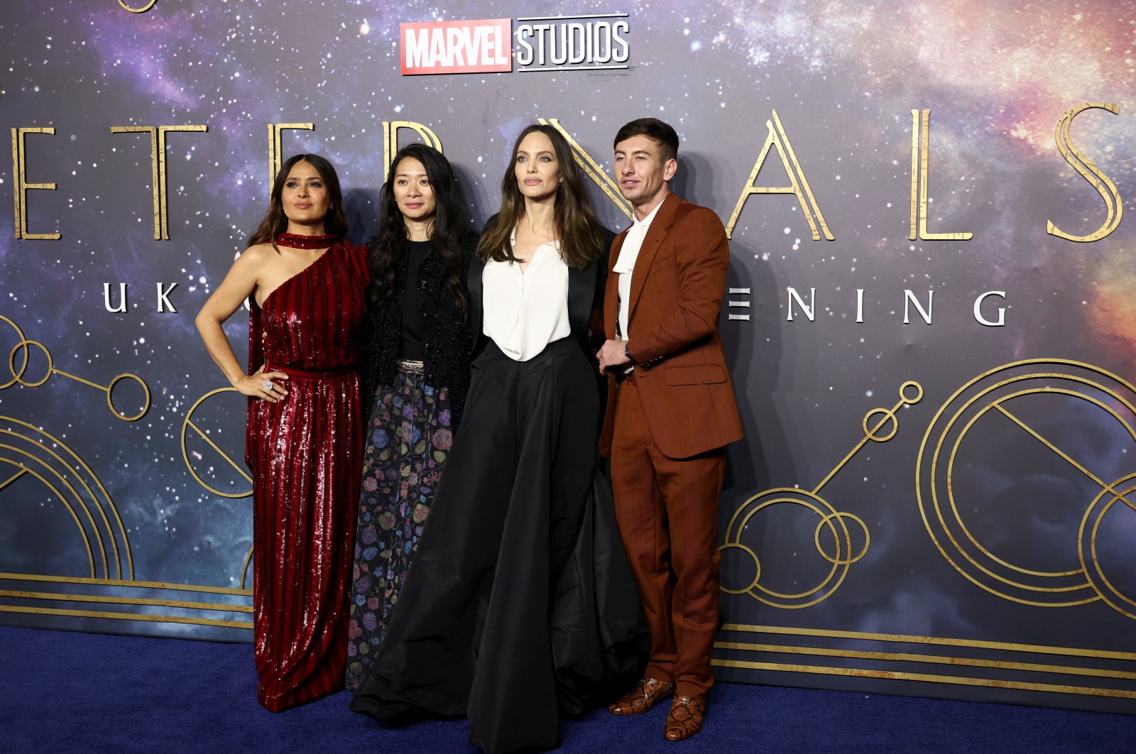 Director Chloe Zhao (C-L) poses with cast members Salma Hayek (L), Angelina Jolie (C-R) and Barry Keoghan as they arrive for a screening of the film "Eternals" in London, U.K., Oct. 27, 2021. (Reuters Photo)