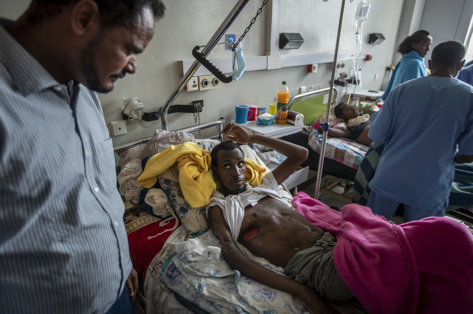 Farmer Teklemariam Gebremichael, who said he was shot by Eritrean forces in Enticho six months before and was still recovering, speaks to a doctor (L) at the Ayder Referral Hospital in Mekele, in the Tigray region of northern Ethiopia on May 6, 2021. (AP Photo)