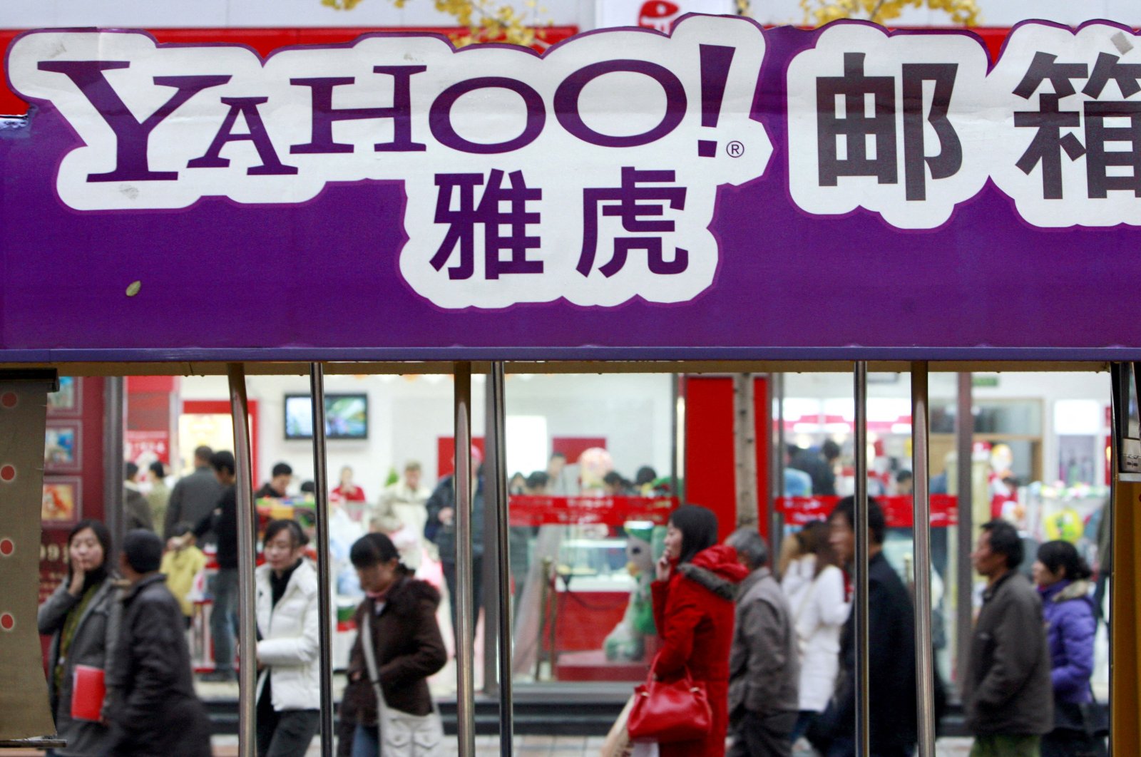 Pedestrians walk past a Yahoo billboard in Beijing, China, Nov. 14, 2007. (AFP Photo)