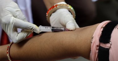 A health worker draws blood from a man. (Getty Images)