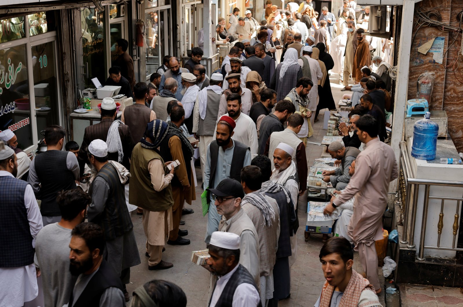 Afghan people walk at a currency exchange market in Kabul, Afghanistan, Oct. 7, 2021. (Reuters Photo)