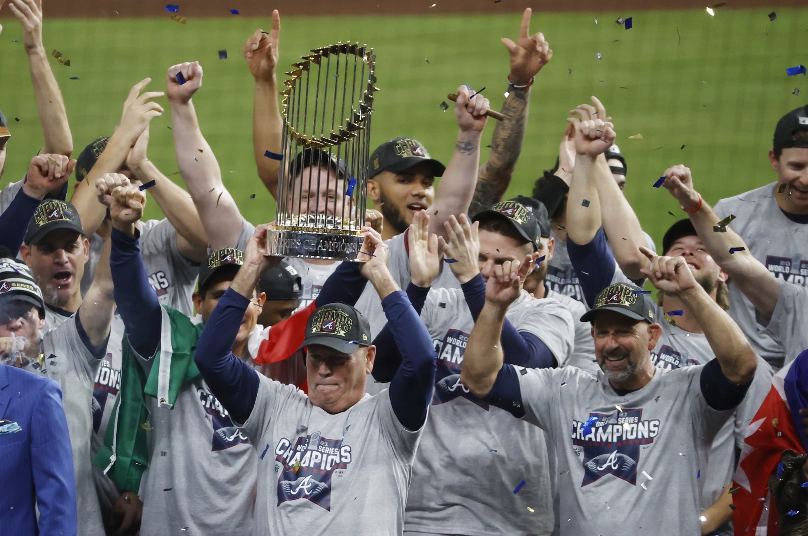 Atlanta Braves manager Brian Snitker hoists the trophy as players and staff celebrate the baseball World Series win over the Houston Astros, Houston, Texas, U.S., Nov. 2, 2021. (AP Photo)