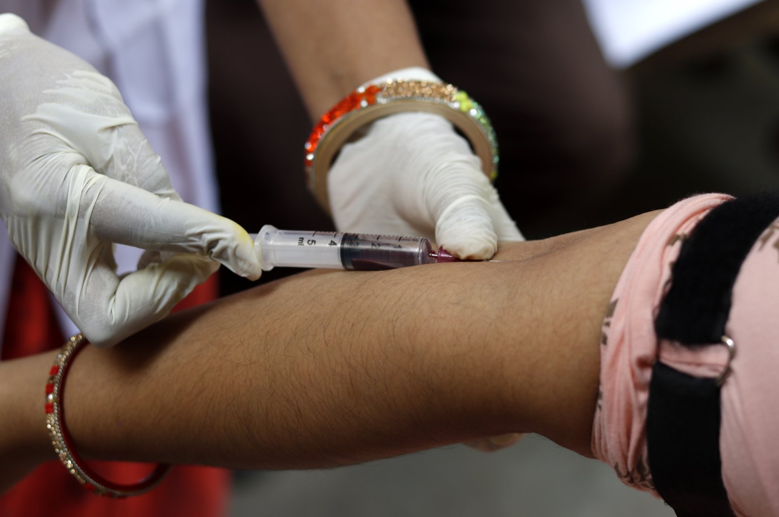 A health worker draws blood from a man. (Getty Images)