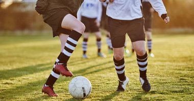 Two female youth footballers vie for the ball in this undated photo.