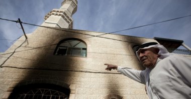 Palestinians inspects the damage on a mosque following an attack in the West Bank village of Mughayer, north of Ramallah, West Bank, occupied Palestine, Nov. 12, 2014. (AP Photo)