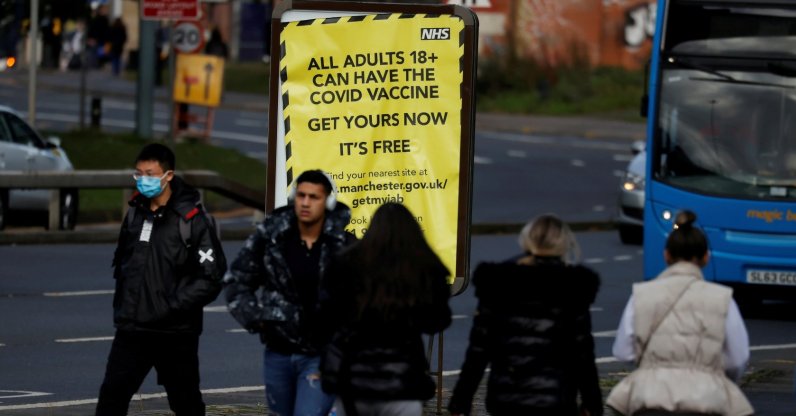 People walk past a sign encouraging the public to get their coronavirus (COVID-19) vaccine doses in Manchester, Britain, Oct. 25, 2021. (Reuters Photo)