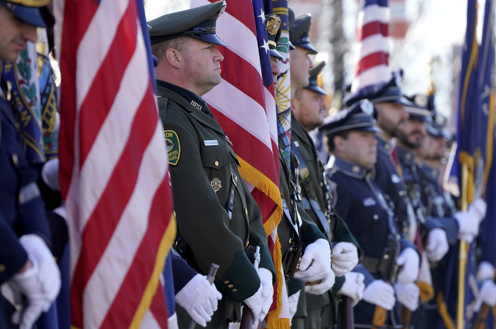 Members of law enforcement display flags outside the SNHU Arena before a Celebration of Life service for fallen N.H. State Police Staff Sergeant Jesse Sherrill, Manchester, New Hampshire, U.S., Nov. 3, 2021. (AP Photo)