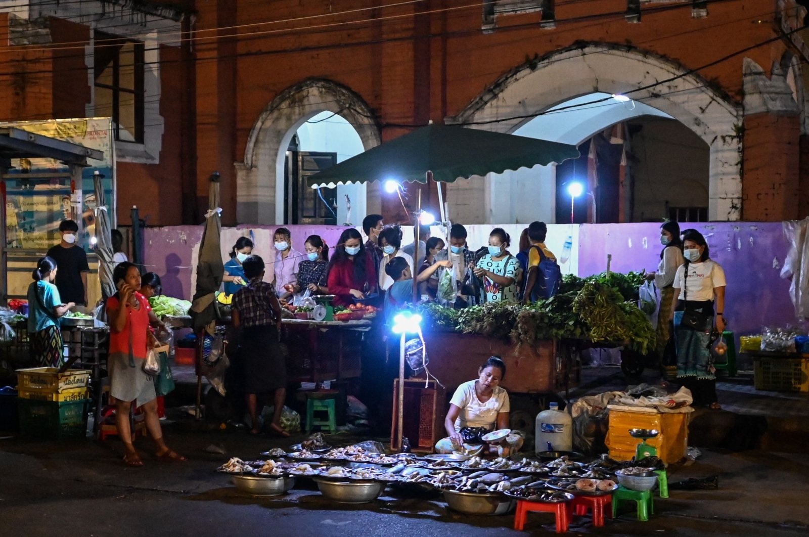 People buy vegetables at a street market in downtown Yangon, Myanmar, Nov. 2, 2021. (AFP Photo)