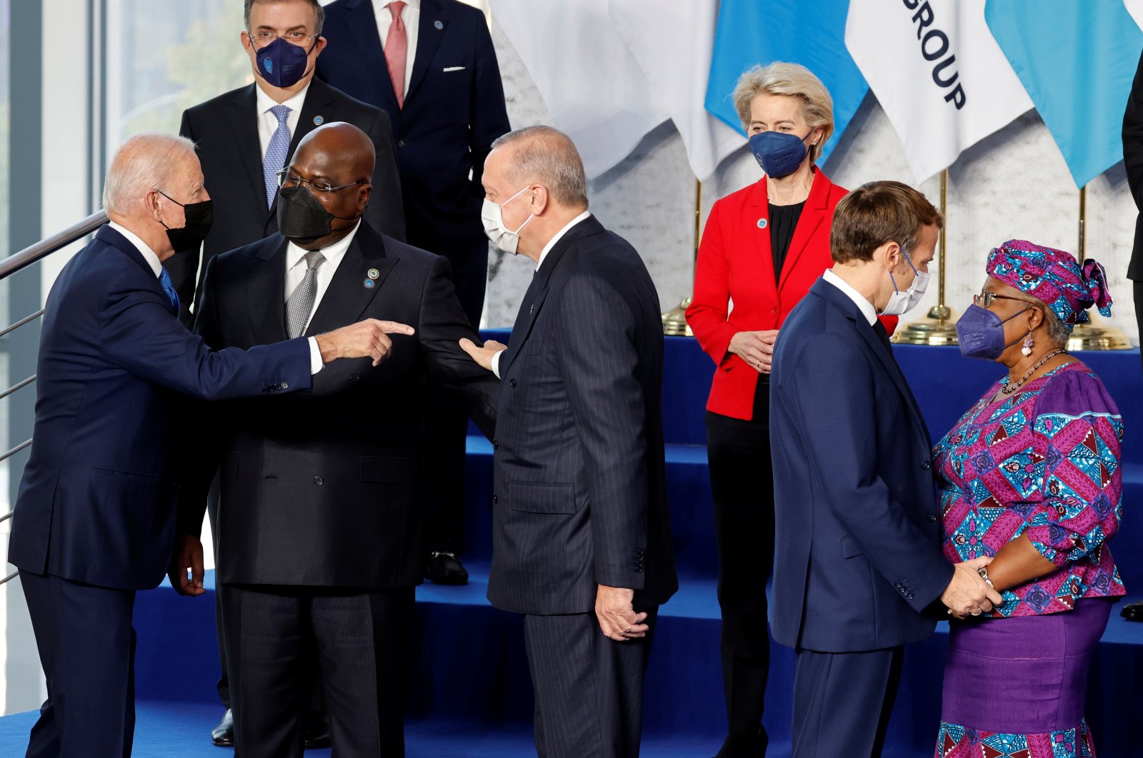 (Foreground) U.S. President Joe Biden (1st L) gestures toward President Recep Tayyip Erdoğan (3rd L) and French President Emmanuel Macron (2nd R) greets Director-General of the World Trade Organization Ngozi Okonjo-Iweala (1st R), as European Commission President Ursula von der Leyen (3rd R) looks on at the start of the G-20 summit at the convention center of La Nuvola, Rome, Italy, Oct. 30, 2021. (Ludovic Marin/Pool via REUTERS)