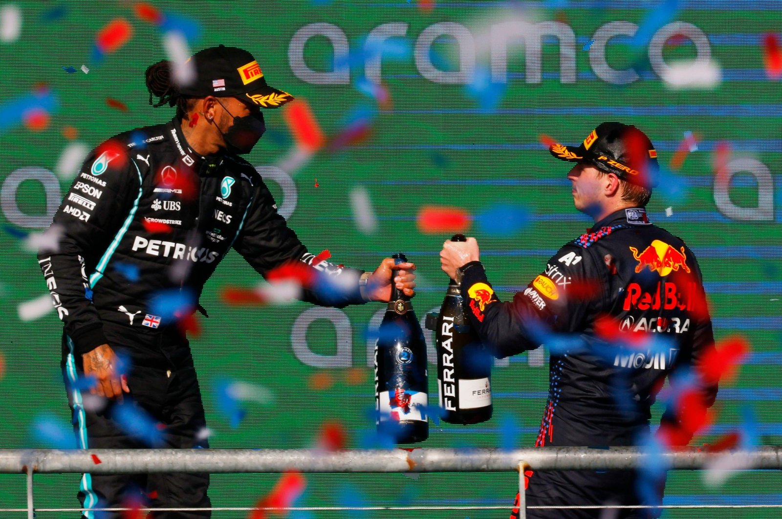 Red Bull's Max Verstappen (R) celebrates on the podium with second-placed Mercedes' Lewis Hamilton after winning the Formula One United States Grand Prix, Austin, Texas, U.S., Oct. 24, 2021. (Reuters Photo)