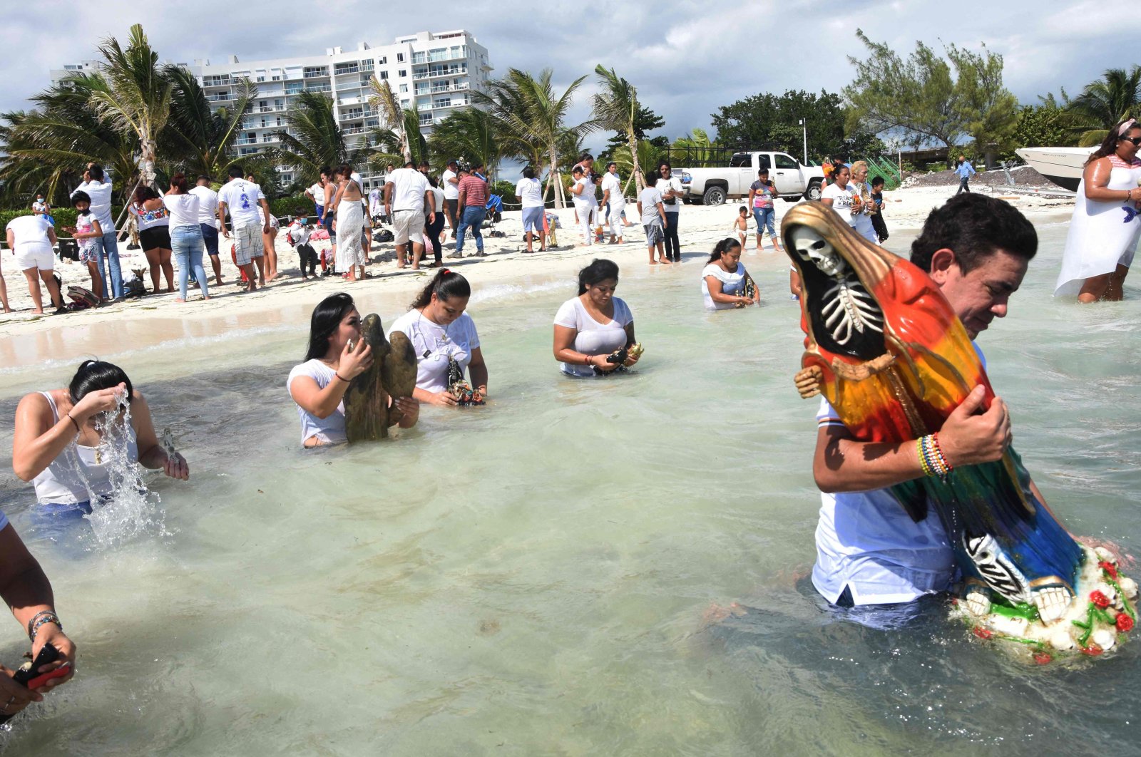 Devotees enter the sea with images of Santa Muerte during a gratitude ceremony for favors received at the beach of Puerto Juarez in Cancun, Quintana Roo state, Mexico, on Nov. 1, 2021. (AFP File Photo)