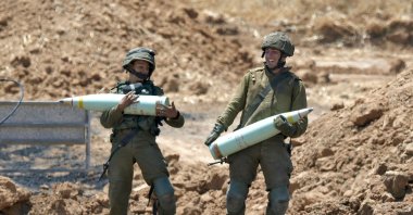 Israeli soldiers prepare to fire artillery shells toward the Gaza Strip from their position near the southern Israeli city of Sderot, May 14, 2021. (AFP Photo )