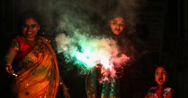 Revelers light a firecracker in a street as part of celebrations during Diwali, the Hindu festival of lights, in Mumbai, India, Nov. 4, 2021. (EPA Photo)
