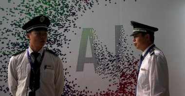 Security officers keep watch in front of an AI (Artificial Intelligence) sign at the annual Huawei Connect event in Shanghai, China, Sept. 18, 2019. (Reuters Photo)