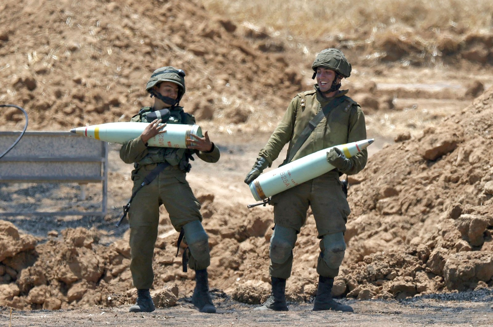 Israeli soldiers prepare to fire artillery shells toward the Gaza Strip from their position near the southern Israeli city of Sderot, May 14, 2021. (AFP Photo )