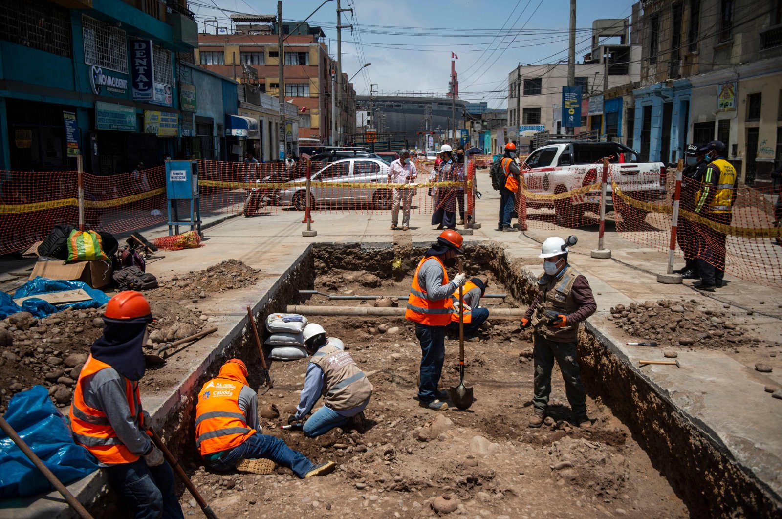 Specialists work around ancient vessels found by a crew laying a natural gas pipe under a street in Lima, Peru, Nov. 4, 2021. (AFP Photo)