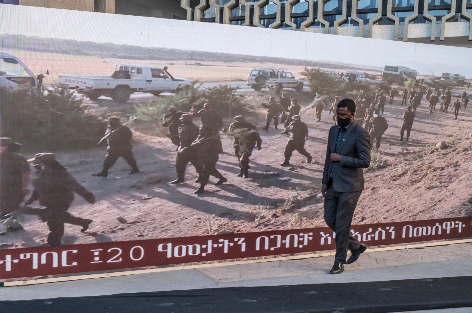 A man walks along a screen featuring soldiers during a memorial service for the victims of the Tigray conflict organized by the city administration, in Addis Ababa, Ethiopia, Nov. 3, 2021. (AFP Photo)