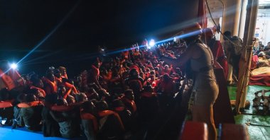 Migrants on a wooden boat wait to be rescued by German NGO search and rescue ship Sea-Eye 4 during a search and rescue (SAR) operation in the Mediterranean Sea, Nov. 3, 2021. (Hugo Le Beller/Sea-Eye/Handout via Reuters)