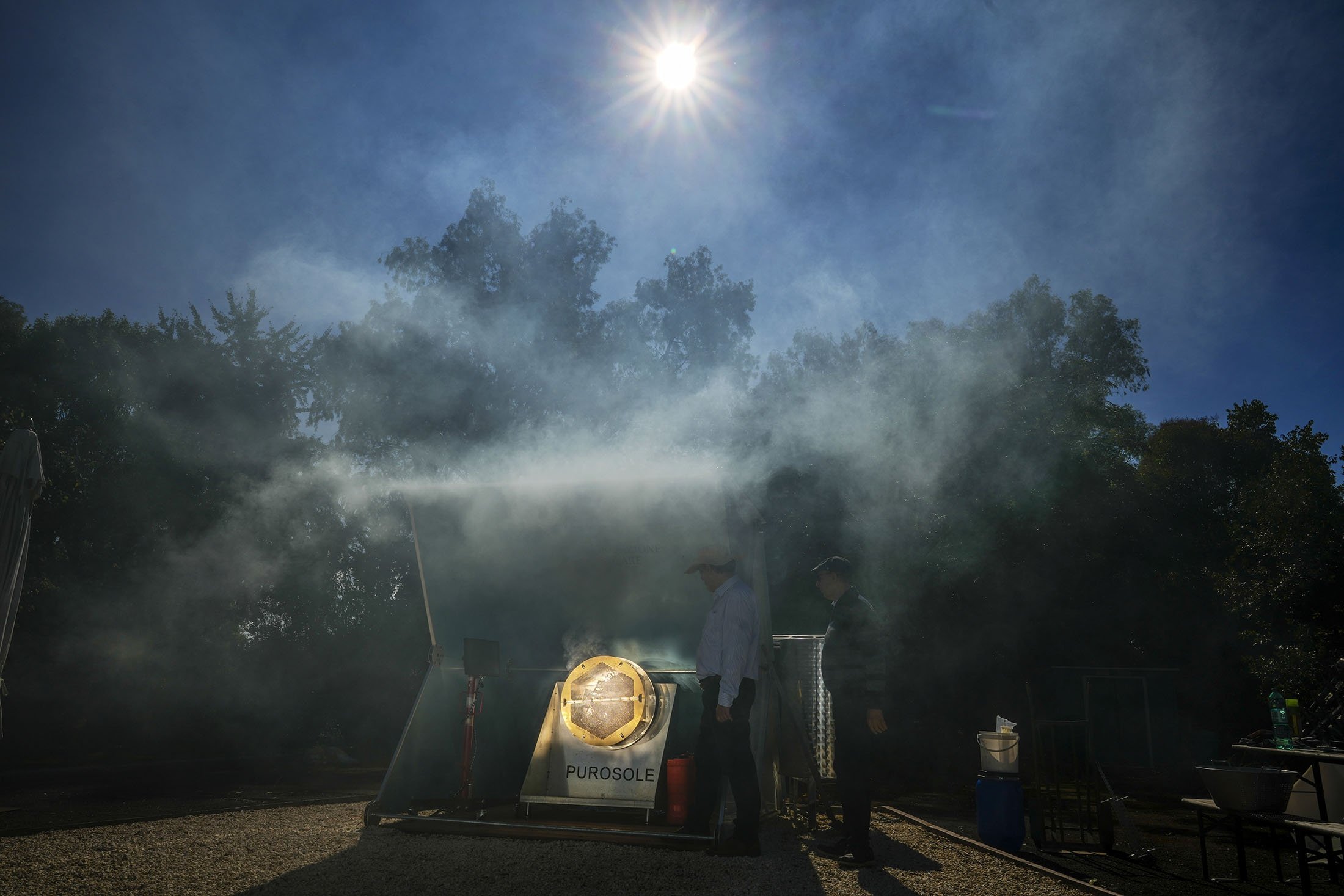 Antonio Durbe (L) and Daniele Tummei monitor the functioning of the "Purosole," or Pure Sun, solar light coffee roaster, in Rome, Italy, Oct. 13, 2021. (AP Photo)