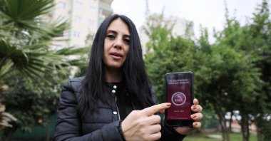 Ayşe Kasanova, who used the app to alert police against her violent ex-husband, shows KADES on her cellphone, in Antalya, southern Turkey, Aug. 11, 2021. (DHA PHOTO) 