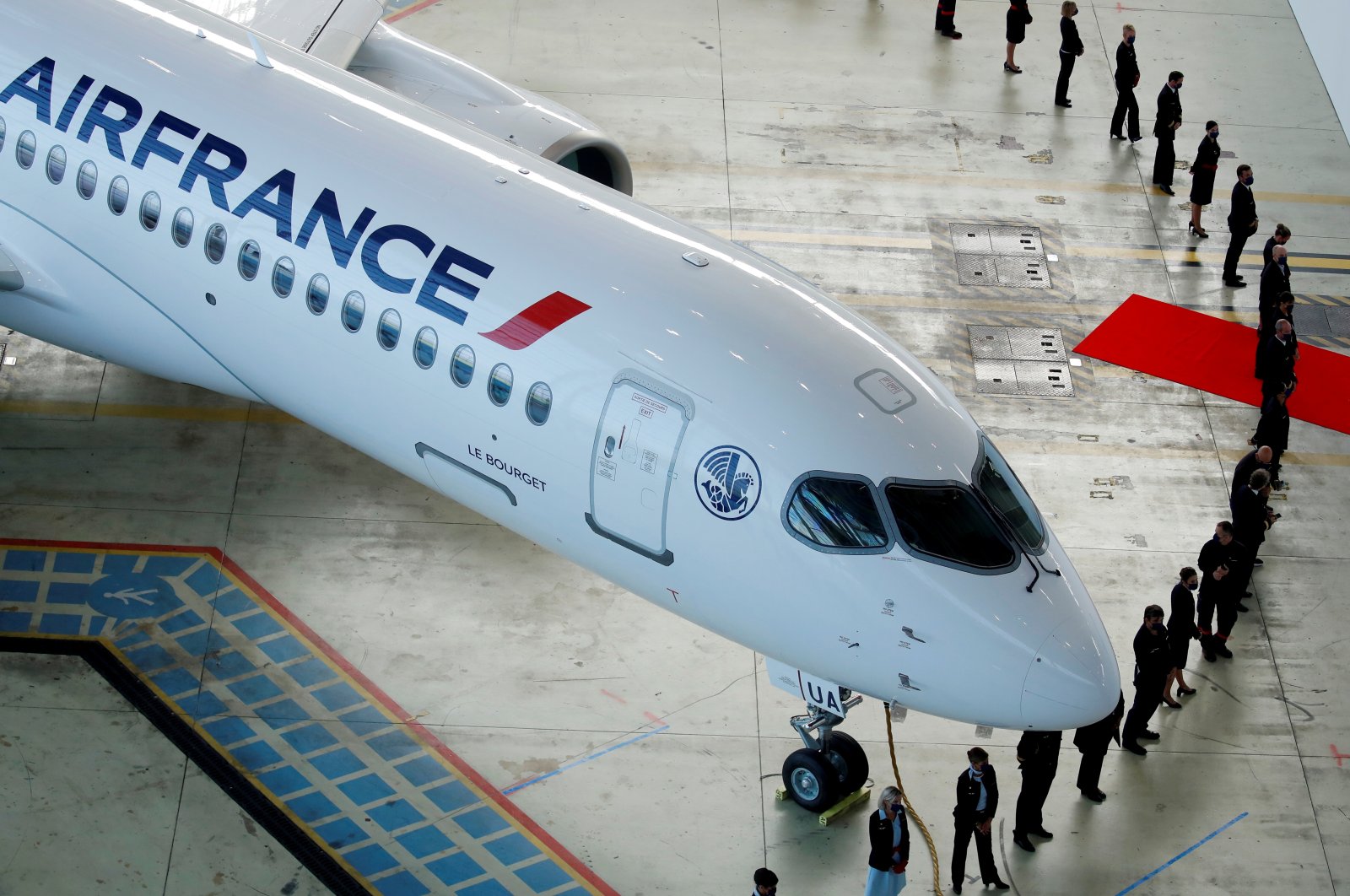 Air France employees stand around the first Air France airliner's Airbus A220 during a ceremony in the Air France hangar at Paris Charles de Gaulle airport in Roissy near Paris, France, Sept. 29, 2021. (Reuters Photo)