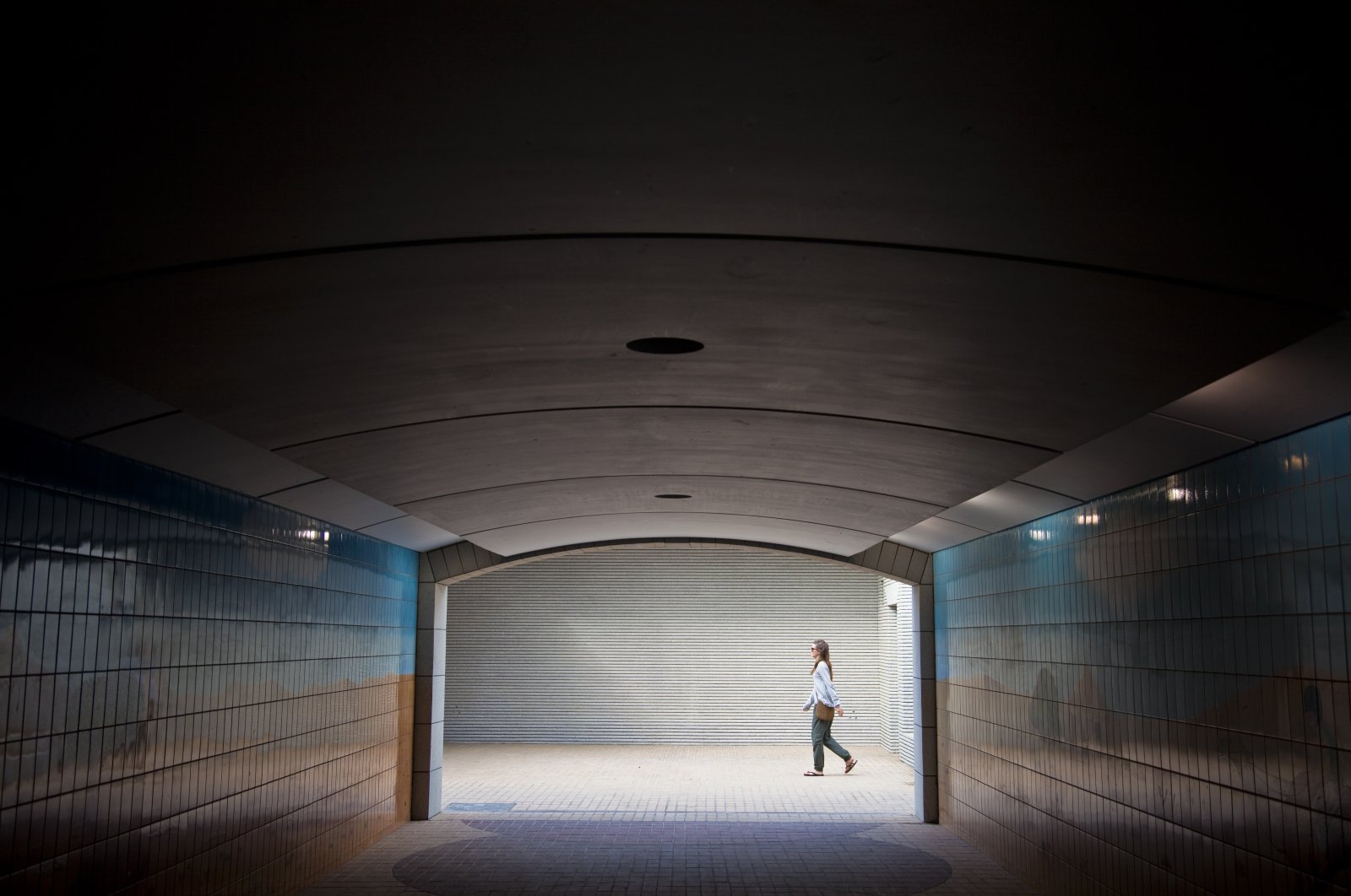 A young woman walks past an underground passage, Abu Dhabi, United Arab Emirates. (Getty Images)