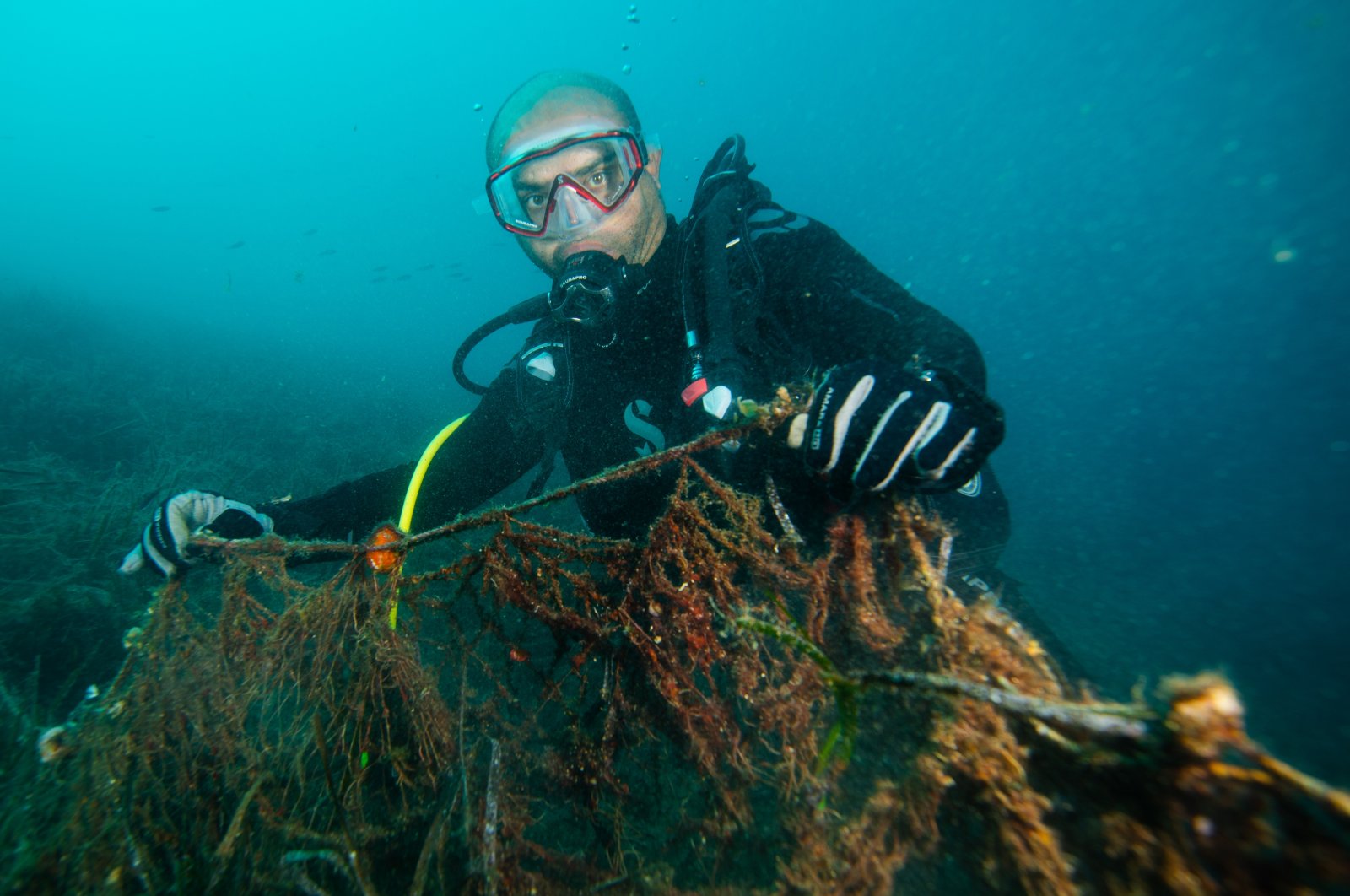 Diver Hamdullah Aras shows a ghost net he removed, off the coast of Izmir, western Turkey, Nov. 6, 2021. (AA PHOTO) 