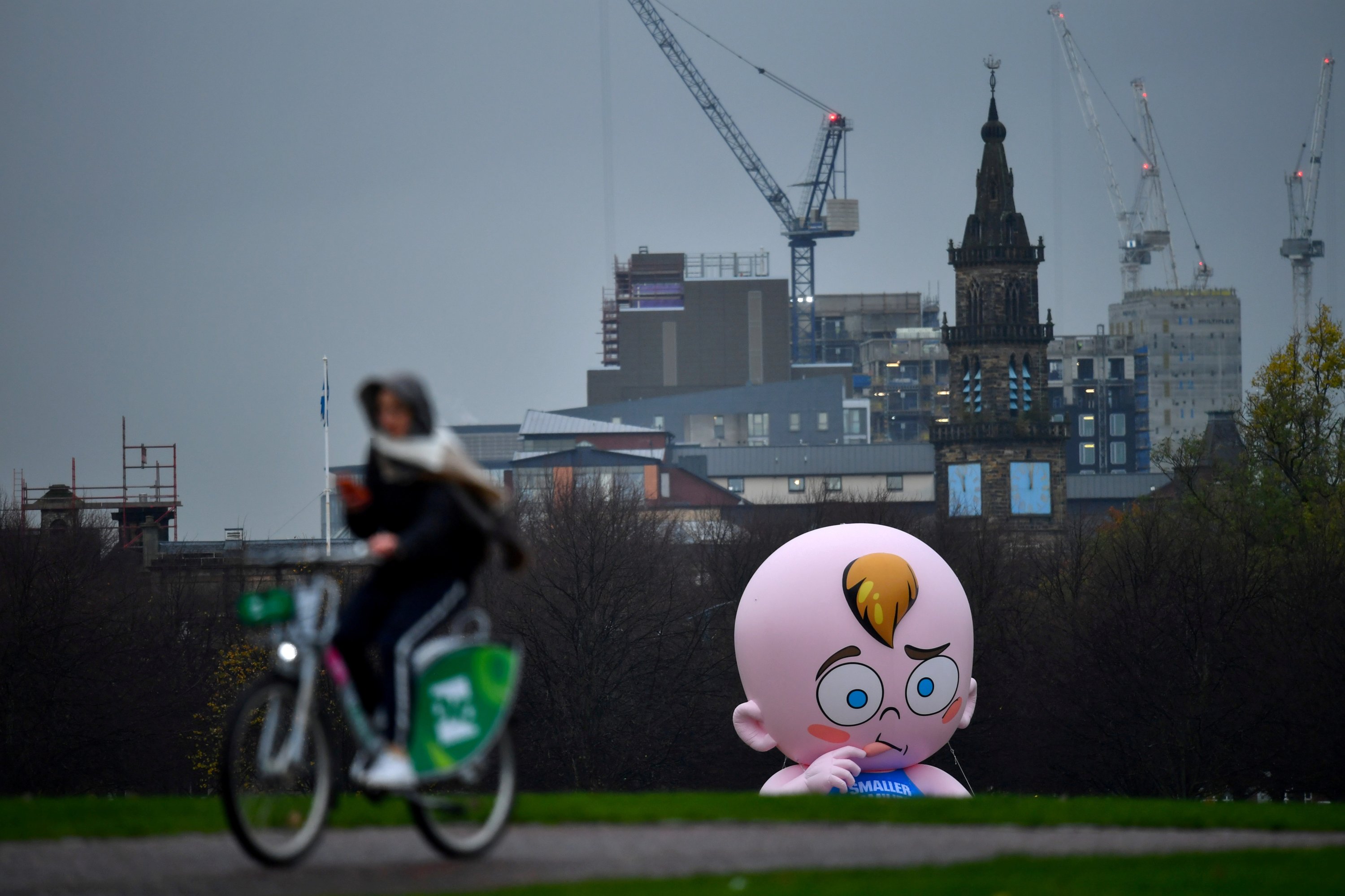 Balon bayi raksasa yang digelembungkan oleh para aktivis Perubahan Iklim terlihat dalam hujan di Glasgow Green saat Konferensi Perubahan Iklim PBB (COP26) berlangsung, di Glasgow, Skotlandia, Inggris, 8 November 2021. (Foto Reuters)