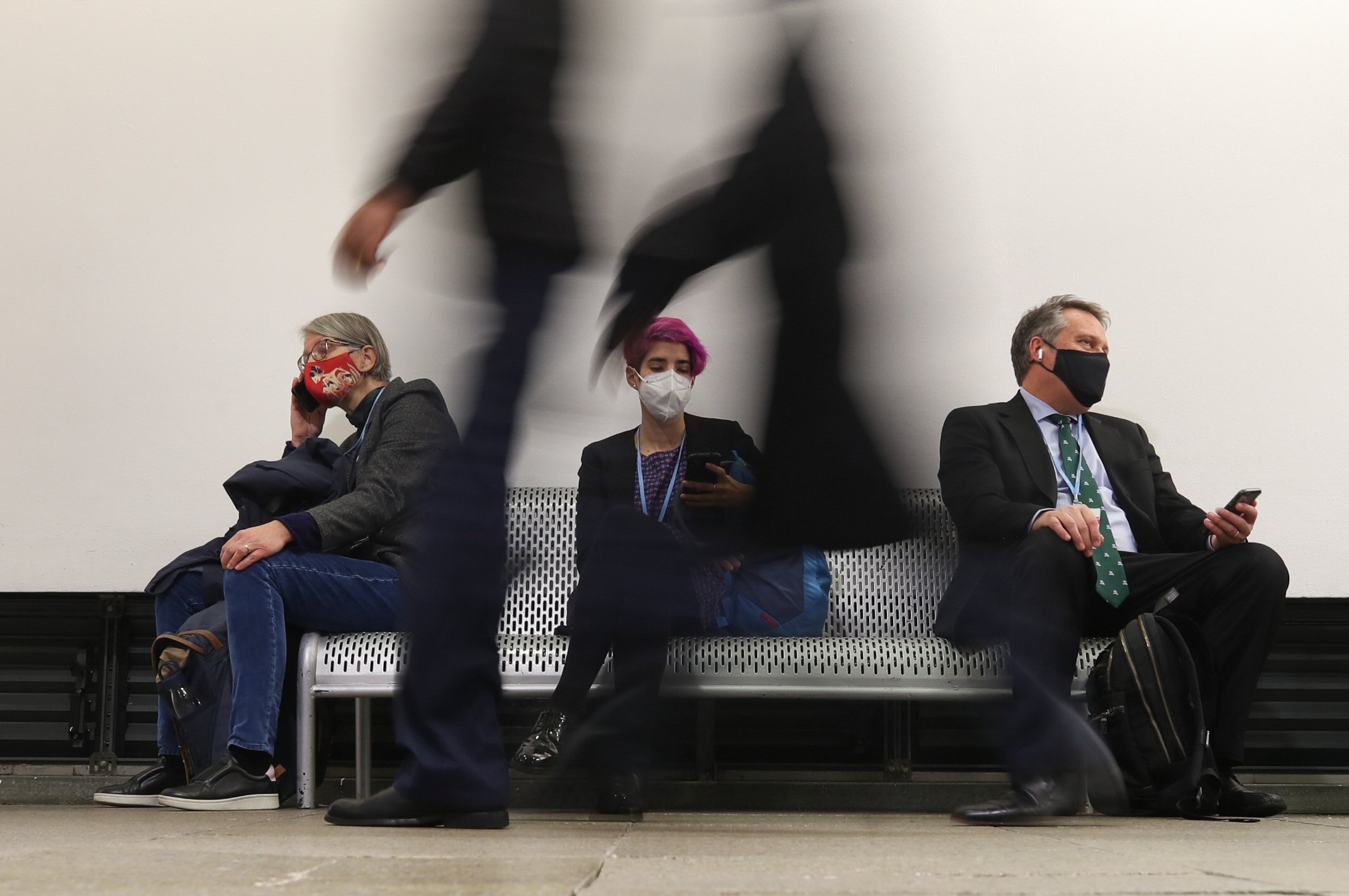 Delegasi beristirahat saat orang-orang berjalan melewati Konferensi Perubahan Iklim PBB (COP26), di Glasgow, Skotlandia, Inggris, 8 November 2021. (Foto Reuters)