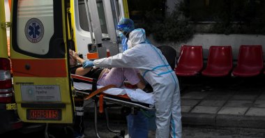 Medical workers wearing personal protective equipment carry a patient on a stretcher, as she arrives on an ambulance at the COVID-19 ward of the Ippokrateio General Hospital in Thessaloniki, Greece, Nov. 3, 2021. (Reuters Photo)