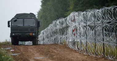 A view of a vehicle next to a fence built by Polish soldiers on the border between Poland and Belarus near the village of Nomiki, Poland, Aug. 26, 2021. (Reuters Photo)