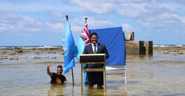 Tuvalu's Minister for Justice, Communication & Foreign Affairs, Simon Kofe gives a COP26 statement while standing in the ocean in Funafuti, Tuvalu, Nov. 5, 2021. (Tuvalu's Ministry of Justice, Communication and Foreign Affairs via Reuters)