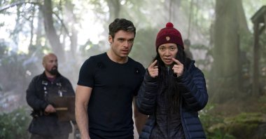 Actor Richard Madden (C), and director Chloe Zhao (R) talk on the set of the Marvel film "Eternals." (Marvel Studios via AP)