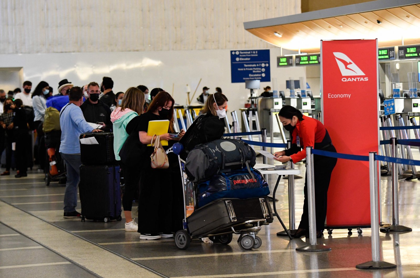 Travelers check-in for a flight to Sydney, Australia on Qantas Airways inside the Tom Bradley International Terminal at Los Angeles International Airport (LAX) in Los Angeles, California, U.S., Nov. 1, 2021. (AFP Photo)