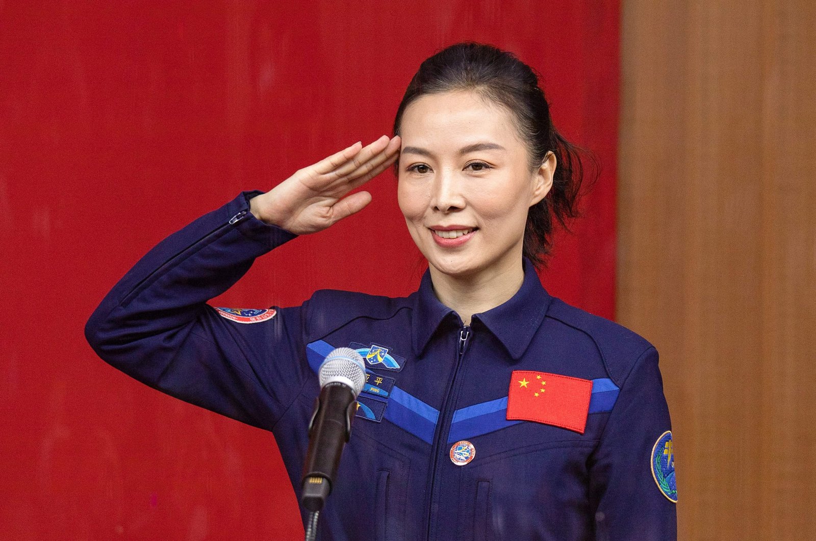 Chinese astronaut Wang Yaping, member of the second crew for China's new space station, salutes during a briefing the day before the launch at the Jiuquan Satellite Launch Center in the Gobi Desert, in northwest China, Oct. 14, 2021. (AFP Photo)