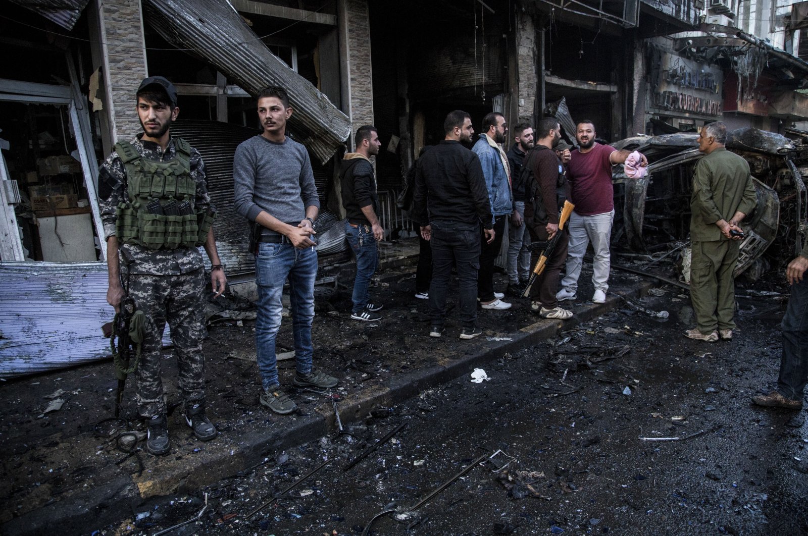People check the aftermath of a YPG/PKK car bomb blast in the city of Qamishli, northern Syria, Monday, Nov. 11, 2019. (AP File Photo)