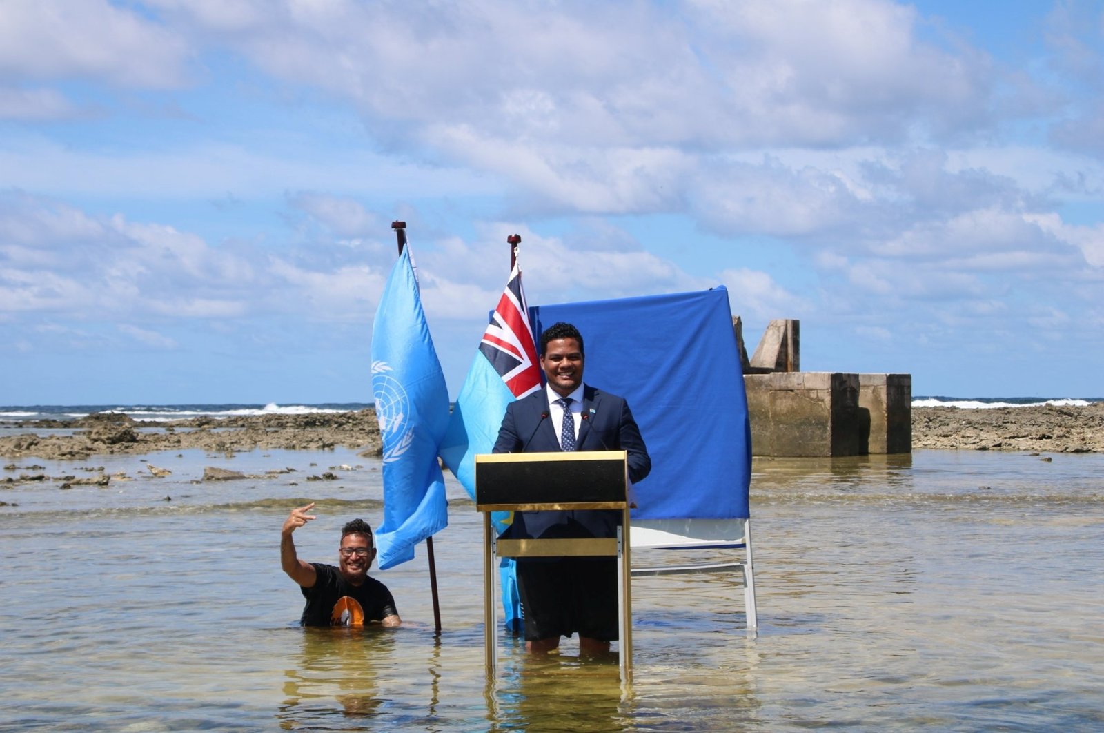 Tuvalu's Minister for Justice, Communication & Foreign Affairs, Simon Kofe gives a COP26 statement while standing in the ocean in Funafuti, Tuvalu, Nov. 5, 2021. (Tuvalu's Ministry of Justice, Communication and Foreign Affairs via Reuters)