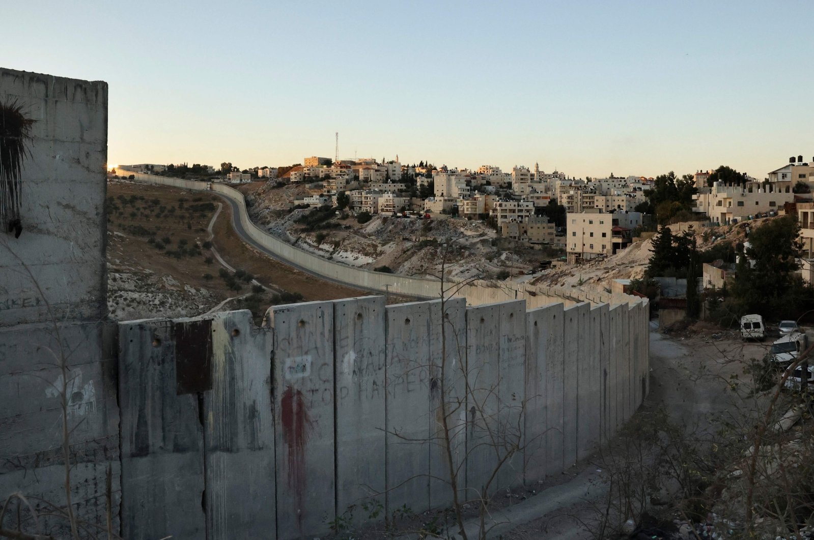 A picture shows Israel's separation barrier cutting through the occupied West Bank town of Abu Dis on the outskirts of Jerusalem, Palestine, Nov. 8, 2021. (Photo by HAZEM BADER / AFP)