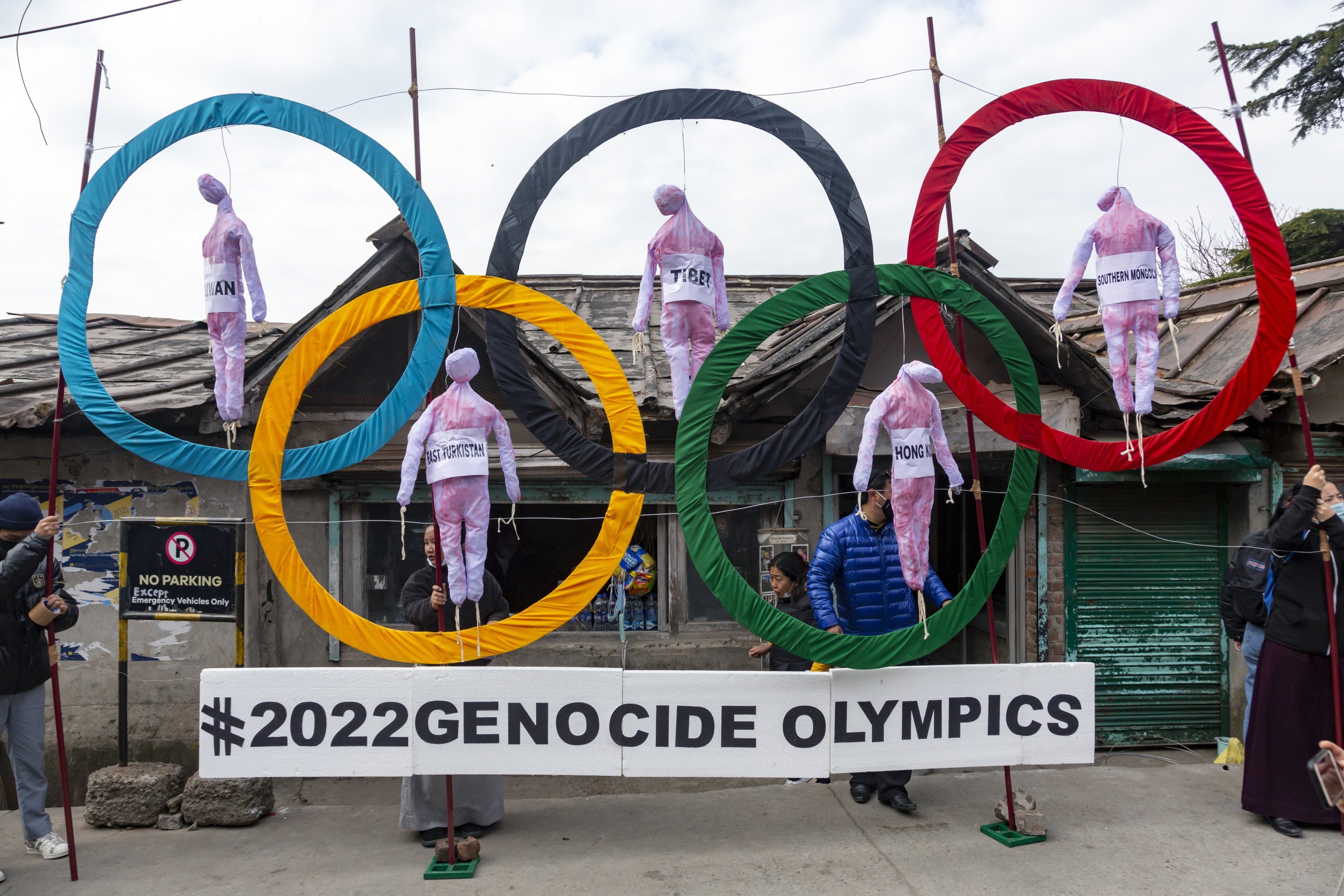 Tibetans use the Olympic Rings as a prop as they hold a street protest against the holding of the 2022 Winter Olympics in Beijing in Dharmsala, Feb. 3, 2021. (AP Photo)