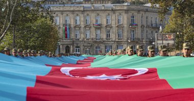 Azerbaijani soldiers carry a large-scale national flag on the anniversary of the end of the 2020 war over the Nagorno-Karabakh region between Azerbaijan and Armenia, in Baku, Azerbaijan, Nov. 8, 2021. (EPA Photo)