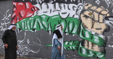 Palestinians walk past a wall painting marking the 104th anniversary of Britain's Balfour Declaration, in Khan Yunis in the southern Gaza Strip, occupied Palestine, Nov. 2, 2021. (AFP Photo)
