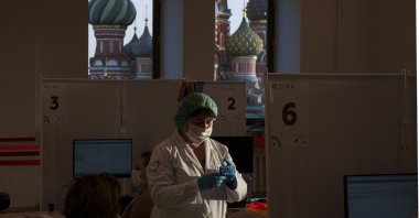 A medical worker prepares a shot of Russia's Sputnik Lite coronavirus vaccine at a vaccination center in the GUM State Department store, in Red Square with the St. Basil Cathedral in the background, in Moscow, Russia, Oct. 26, 2021. (AP Photo)
