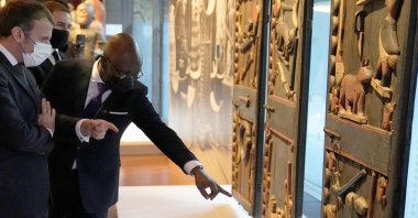 French President Emmanuel Macron (L) looks at the doors of Benin King Glele's palace exhibited at the Quai Branly museum before being shipped to the West African country, in Paris, France, Oct. 27, 2021. (AFP Photo)
