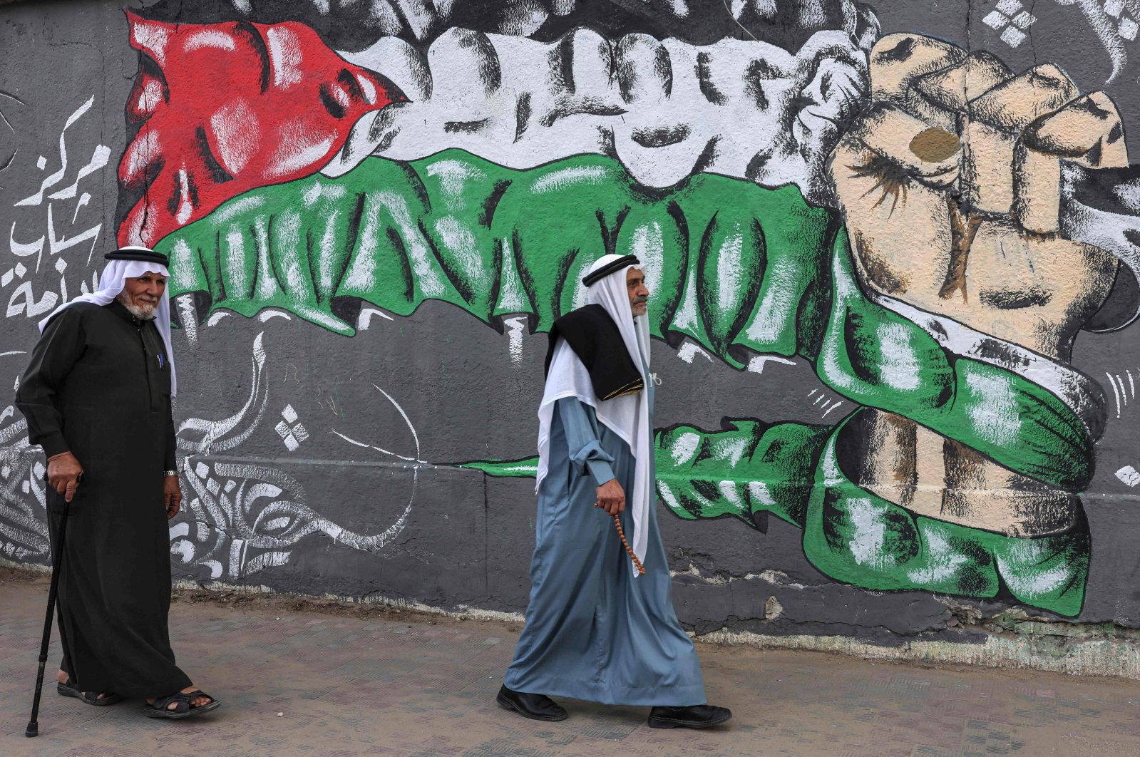 Palestinians walk past a wall painting marking the 104th anniversary of Britain's Balfour Declaration, in Khan Yunis in the southern Gaza Strip, occupied Palestine, Nov. 2, 2021. (AFP Photo)