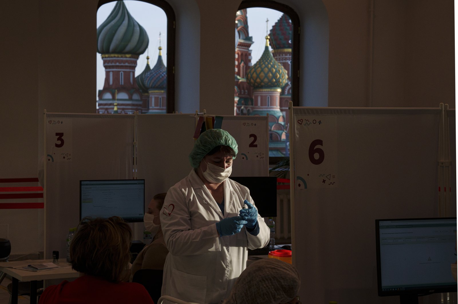 A medical worker prepares a shot of Russia's Sputnik Lite coronavirus vaccine at a vaccination center in the GUM State Department store, in Red Square with the St. Basil Cathedral in the background, in Moscow, Russia, Oct. 26, 2021. (AP Photo)