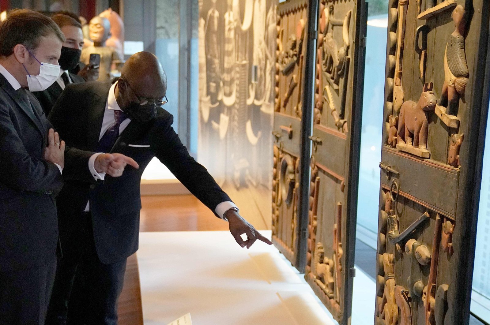 French President Emmanuel Macron (L) looks at the doors of Benin King Glele's palace exhibited at the Quai Branly museum before being shipped to the West African country, in Paris, France, Oct. 27, 2021. (AFP Photo)