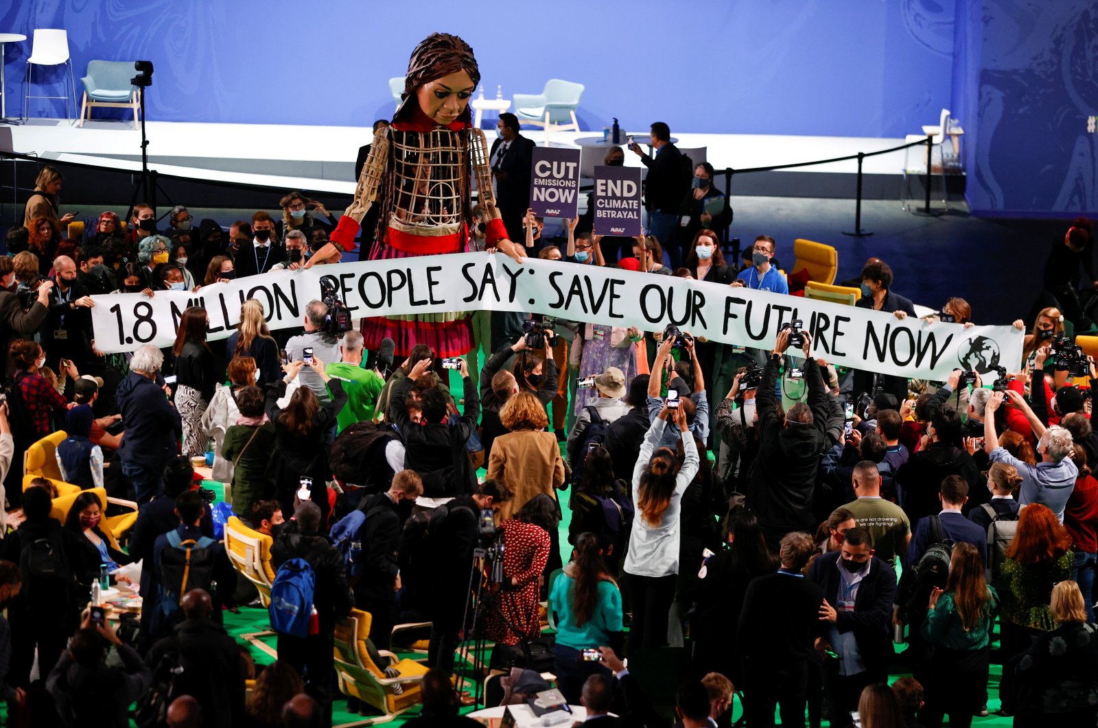 People gather around "Little Amal," a 3.5-meter tall puppet of a young Syrian refugee girl, during the U.N. Climate Change Conference (COP26) in Glasgow, Scotland, Britain, Nov. 9, 2021. (Reuters Photo)