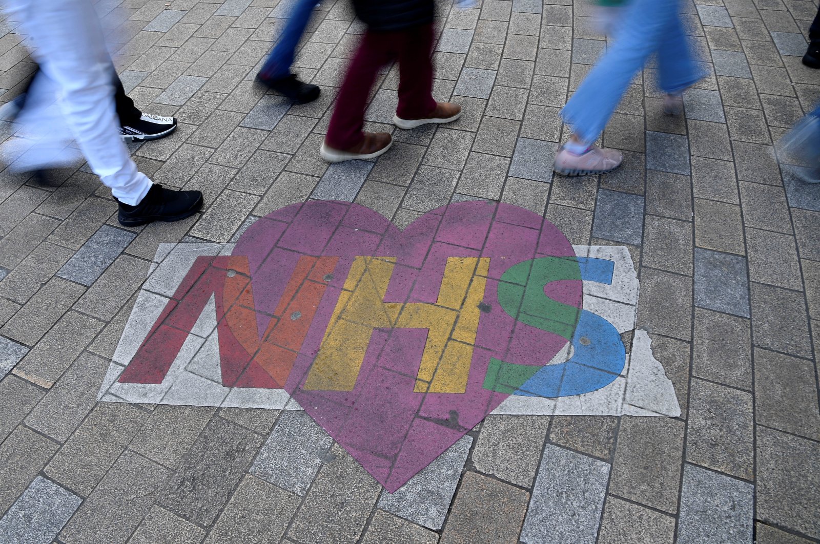 Shoppers walk past a mural denoting appreciation for the U.K. National Health Service, amidst the spread of the coronavirus pandemic, Oxford Street in London, Britain, Oct. 20, 2021. (Reuters Photo)
