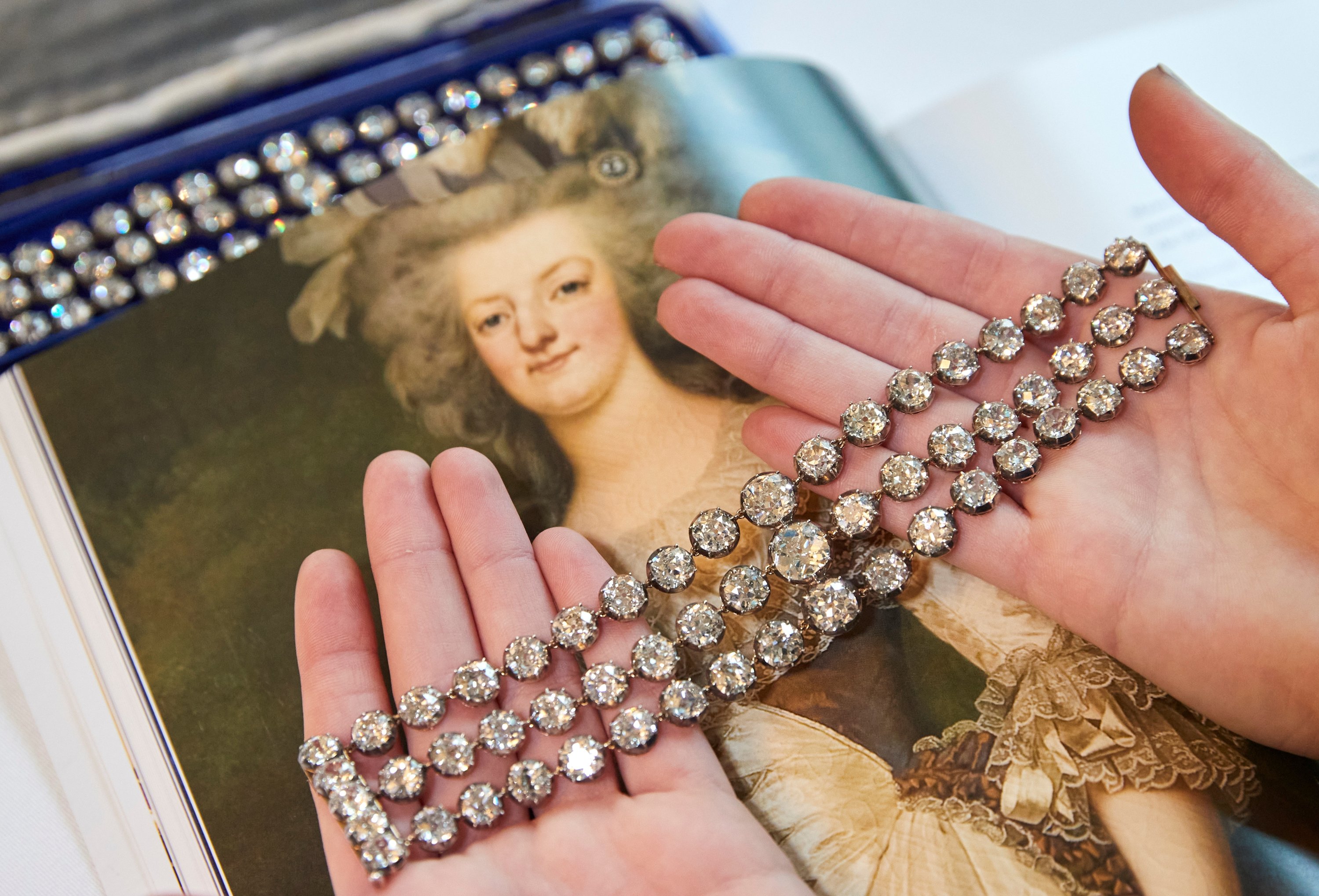Seorang anggota staf menampilkan sepasang gelang berlian milik Ratu Marie-Antoinette dari Prancis, dalam warna perak dan emas kuning, sekitar tahun 1776, selama pratinjau di Christie